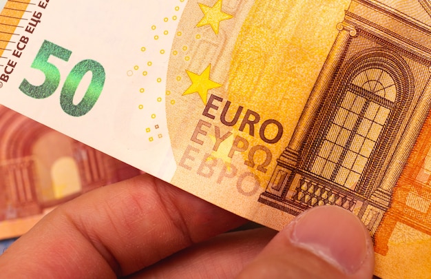 Ein mann, der einen fünfzig-euro-schein hält | Premium-Foto