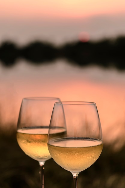 Ein Romantisches Abendessen Im Sommer Am Strand Bei Sonnenuntergang Mit Zwei Glasern Weisswein Premium Foto