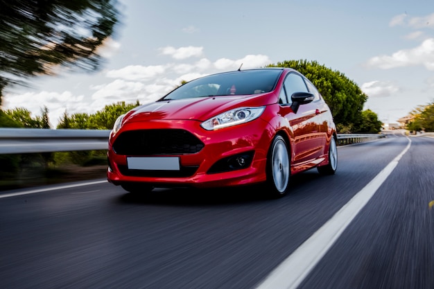 Ein rotes mini-coupé, das auf der autobahn mit hoher geschwindigkeit fährt. Kostenlose Fotos