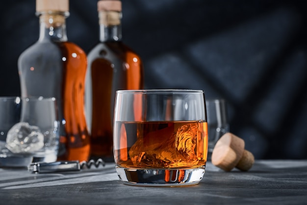 Ein rundes glas whisky mit eis auf dem tisch PremiumFoto