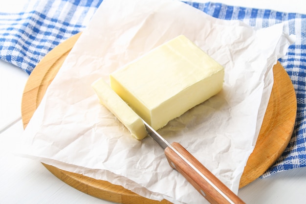 Ein Stuck Butter Auf Einem Holzernen Brett Mit Einem Messer Auf Einer Weissen Tabelle Zutaten Zum Kochen Premium Foto