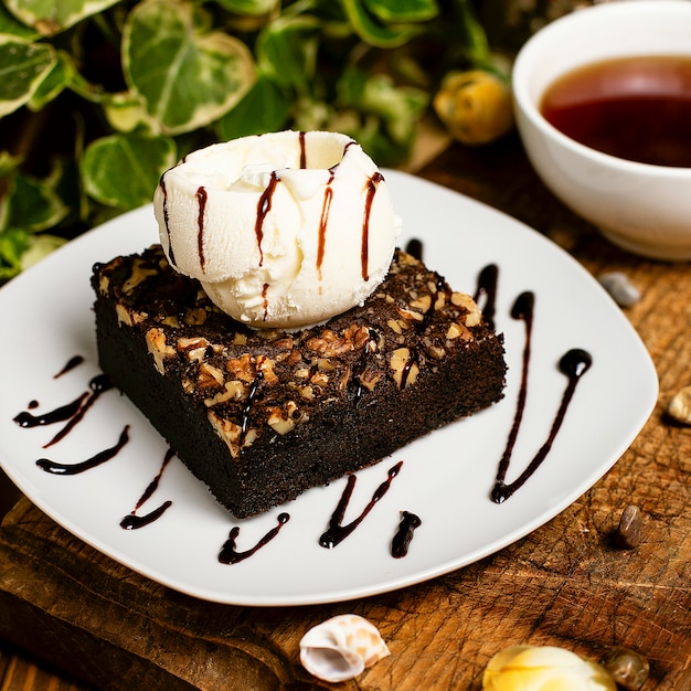 Ein stück schokoladen-brownie mit walnuss-vanille-eis. | Kostenlose Foto