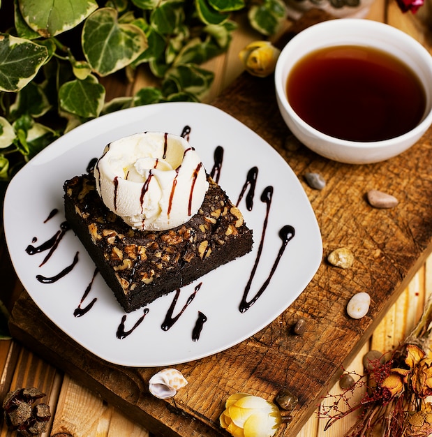 Ein stück schokoladen-brownie mit walnuss-vanille-eis. | Kostenlose Foto