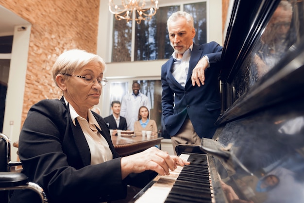 Eine ältere frau spielt klavier in einem pflegeheim Premium Fotos