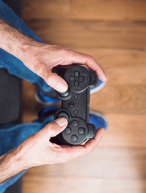 Eine draufsicht der hand des älteren mannes, die videospielkonsole hält Kostenlose Fotos