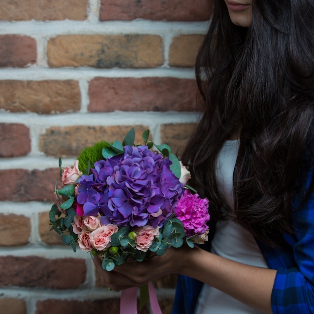 Eine Frau Die Einen Blumenstrauss Von Purpurroten Blumen In Der Hand Halt Kostenlose Foto