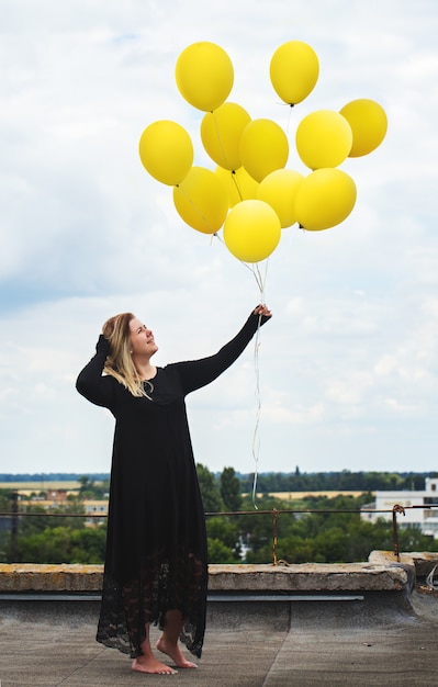 Eine Frau Mit Einem Grossen Haufen Luftballons Premium Foto