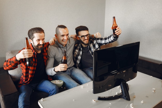 Eine gruppe von fans schaut fußball im fernsehen Kostenlose Fotos