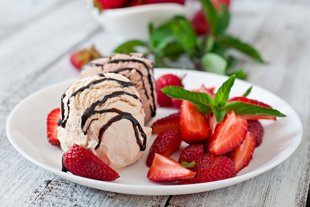 Eis mit erdbeeren und schokolade auf einem weißen teller | Kostenlose Foto
