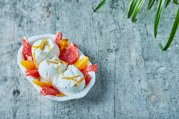 Eis mit grapefruit und orangenscheiben in weißer schüssel | Kostenlose Foto