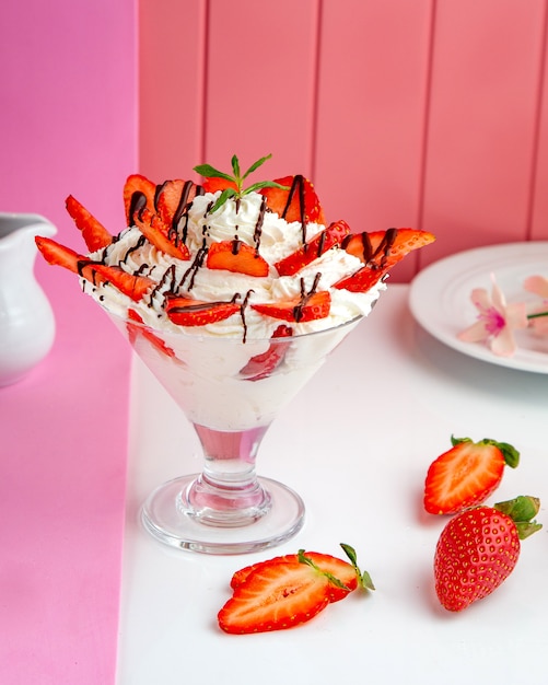 Erdbeerdessert mit schlagsahne schokolade und erdbeere auf dem tisch ...