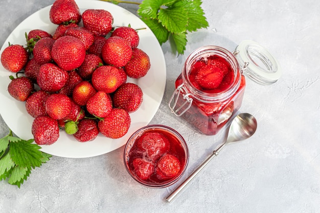 Erdbeermarmelade in einem glas neben frischen erdbeeren | Premium-Foto