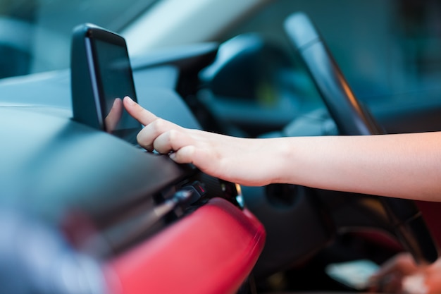 Fahrerhand, die eine adresse in das navigationssystem oder in das radiolied im auto eingibt Premium Fotos