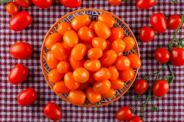 Farbige tomaten in einer flachen platte lagen auf einem picknicktuch ...