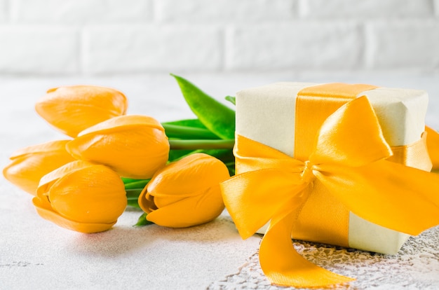 Feiertagshintergrund mit tulpen und geschenkbox Premium Fotos