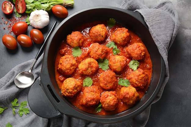 Fleischbällchen in süßer tomatensauce mit gewürzen in einer pfanne ...