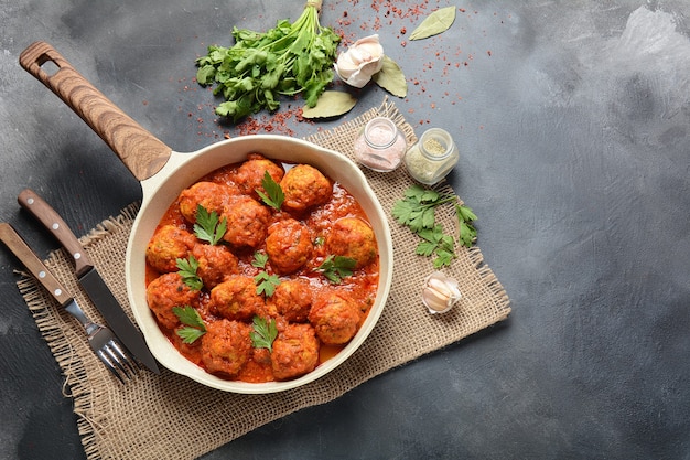 Fleischbällchen in süßer tomatensauce mit gewürzen in einer pfanne ...