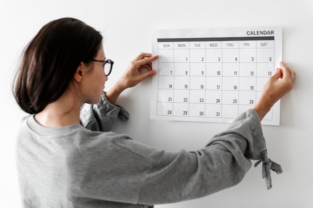 Frau, die den kalender überprüft  Kostenlose Foto