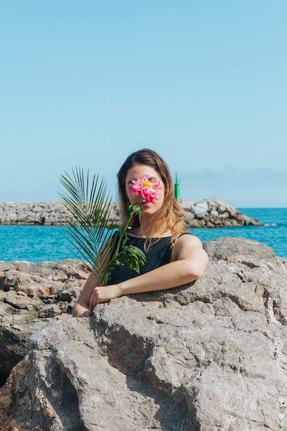 Frau Die Ihr Gesicht Mit Der Schonen Blume Steht Nahes Meer Versteckt Kostenlose Foto