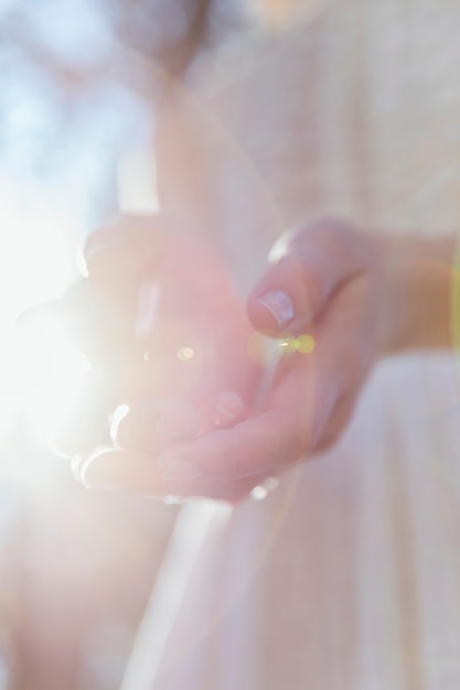 Frau, die im sonnenlicht ihre hände hält Kostenlose Fotos
