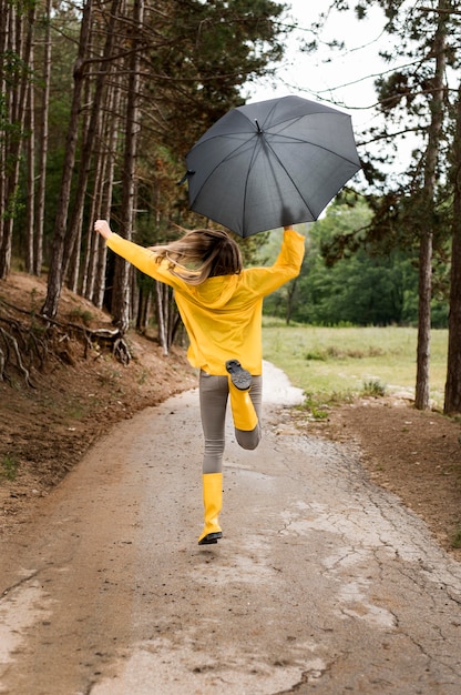 Frau Die Im Wald Lauft Wahrend Sie Einen Regenschirm Halt Kostenlose Foto