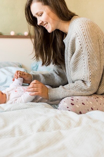 Frau Die Mit Baby Auf Bett Spielt Kostenlose Foto