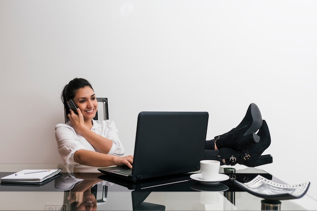 Frau, die von zu hause mit ihrem laptop arbeitet, der auf