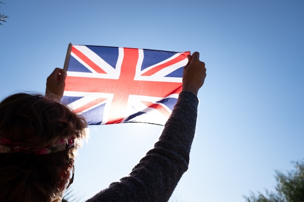 Frau Halt Die Flagge Von Grossbritannien Gegen Die Sonne In Einem Patriotischen Moment Premium Foto