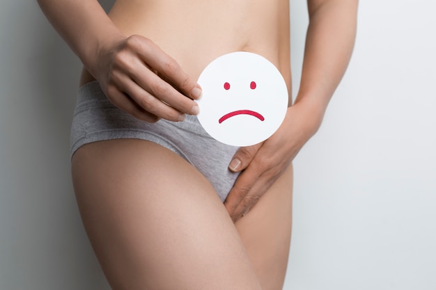 Frau hält ein trauriges gesicht mit schmerzlicher regelblutung Premium Fotos