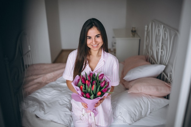 Frau mit blumenstrauß von blumen im schlafzimmer Kostenlose Fotos