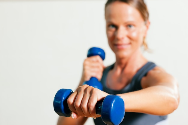 Frau mit hanteln im fitnessstudio Premium Fotos