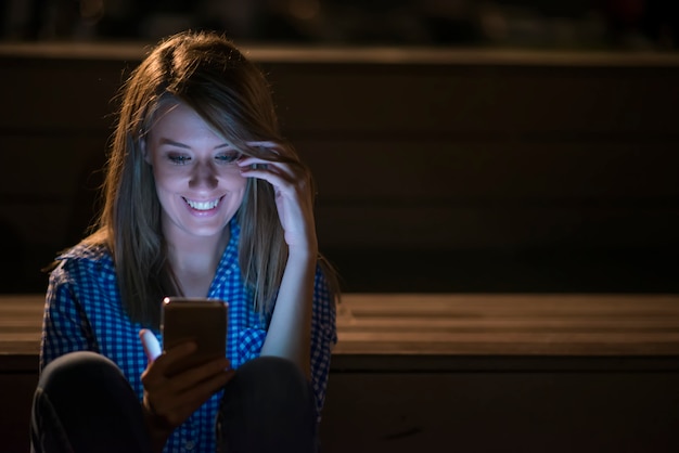 Frau sms. closeup junge glücklich lächelnd fröhlich schöne frau mädchen blick auf handy handy lesen senden sms isoliert stadtbild im freien hintergrund. positives gesichtsausdruck menschliches gefühl Kostenlose Fotos