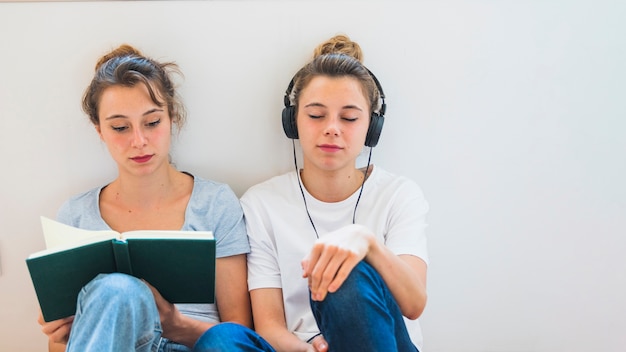 Frauenlesebuch Das Nahe Der Horenden Musik Der Frau Auf Kopfhorer Sitzt Kostenlose Foto