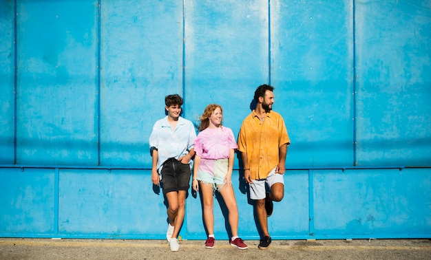 Freunde, die mit blauer wand aufwerfen Kostenlose Fotos