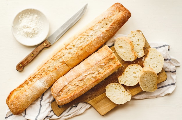 Frische baguettes mit einer knusprigen kruste, gehackt auf einem schneidebrett Premium Fotos