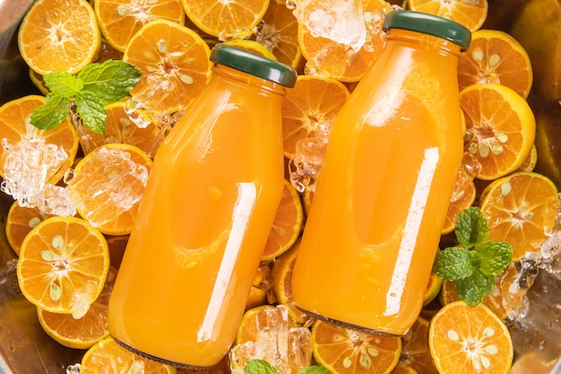 Frischer orangensaft im glasgefäß mit minze, frischen früchten ...