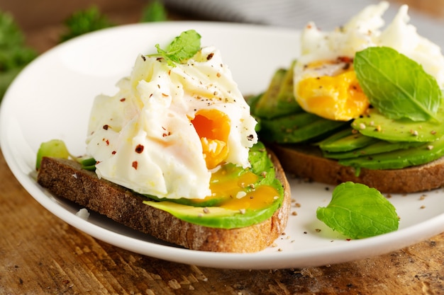 Frisches sandwich mit avocado und pochiertem ei auf brot ...