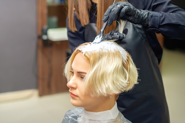 Friseur In Schwarzen Handschuhen Farbt Haare Der Jungen Frau In Weisser Farbe Im Friseursalon Premium Foto