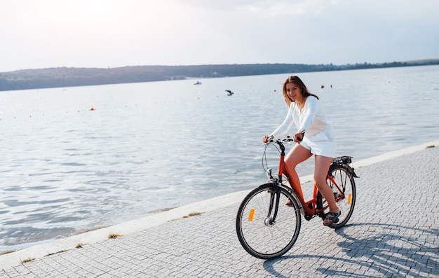 Fröhliches mädchen fährt am sonnigen tag mit dem fahrrad