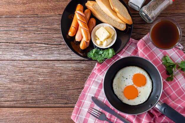 Frühstücken sie mit spiegelei auf wanne- und wurstgrill mit toast, kaffee auf tabelle Premium Fotos