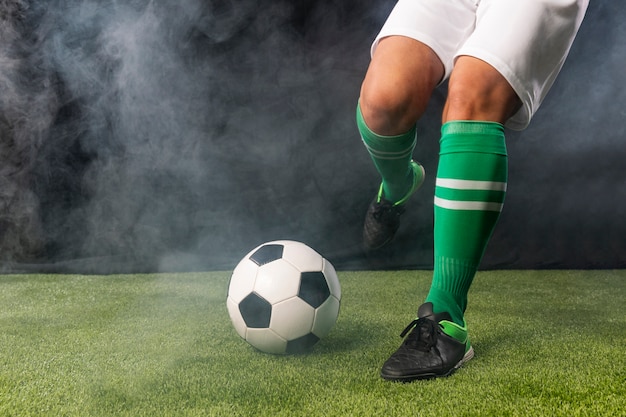 Fußballspieler in der sportkleidung, die ball tritt Kostenlose Fotos