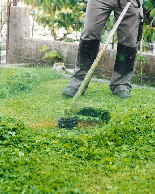 Gärtner, der das gras mäht Kostenlose Foto