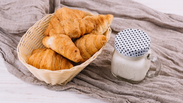 Gebackene hörnchen und milch in geschlossenem einmachglas auf ...