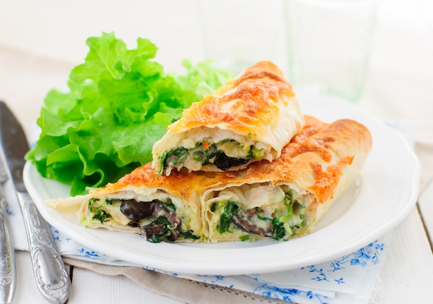 Gebackene tortilla brötchen mit spinat, hähnchen und champignons Premium Fotos