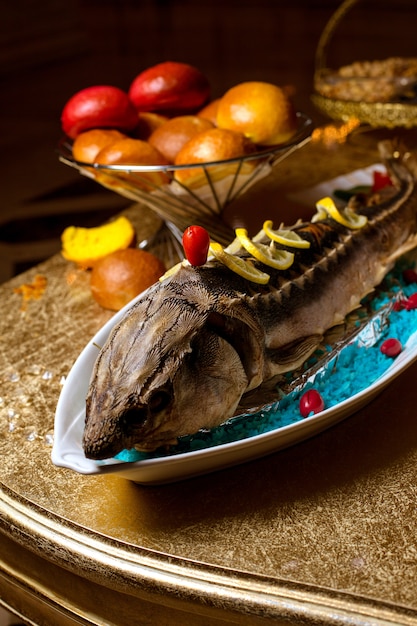 Gebratener fisch mit zitronenscheiben auf dem tisch | Kostenlose Foto