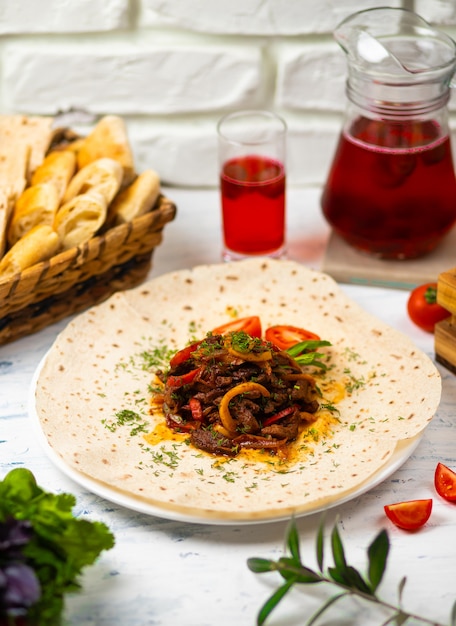 Gebratenes fleisch und gemüse mit kräutern auf einer weißen platte mit brotgemüse und glas wein Kostenlose Fotos