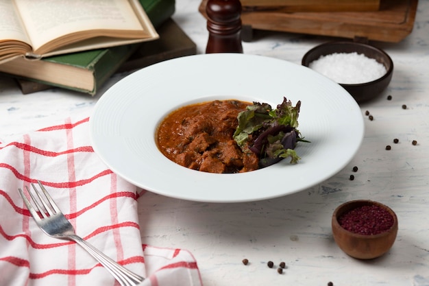 Gebratenes lammfleisch, eintopf in browh und tomatensauce, serviert mit gemüse und sumakh. Kostenlose Fotos