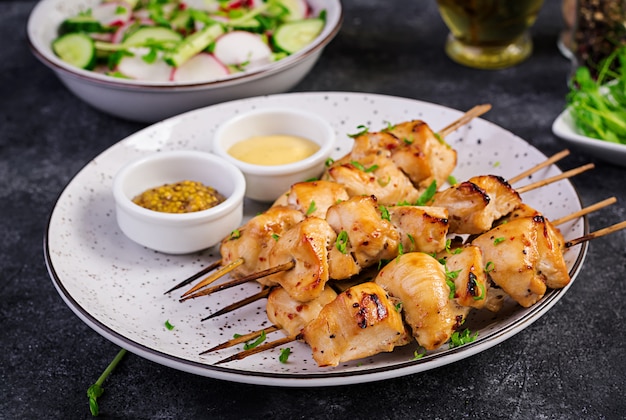 Gegrillter hühnerkebab und -salat mit gurke, rettich, zwiebel Premium Fotos