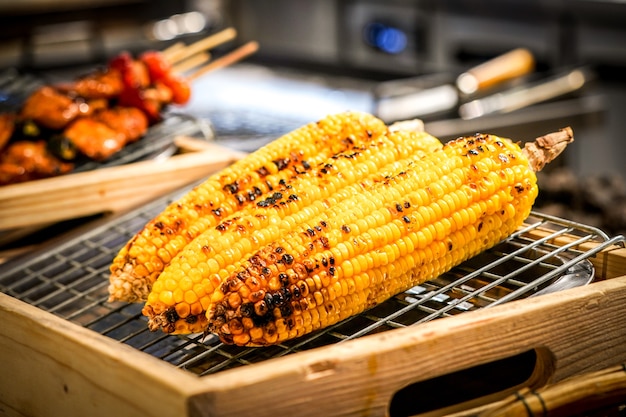 Gegrillter mais auf dem grill mit unschärfe bbq dazu | Premium-Foto