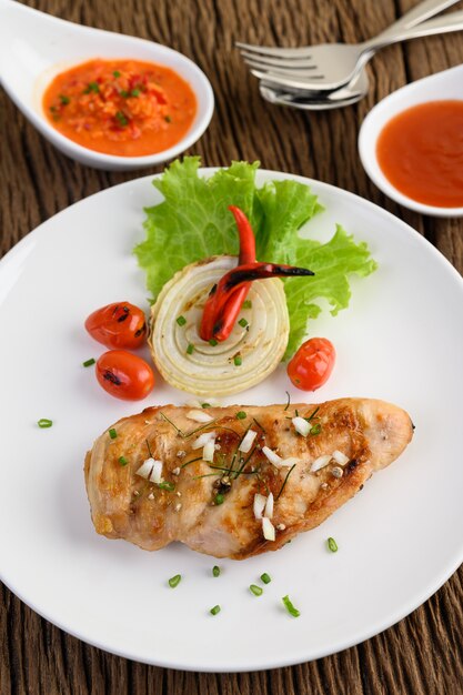 Gegrilltes hähnchen auf einem weißen teller mit tomaten, salat ...